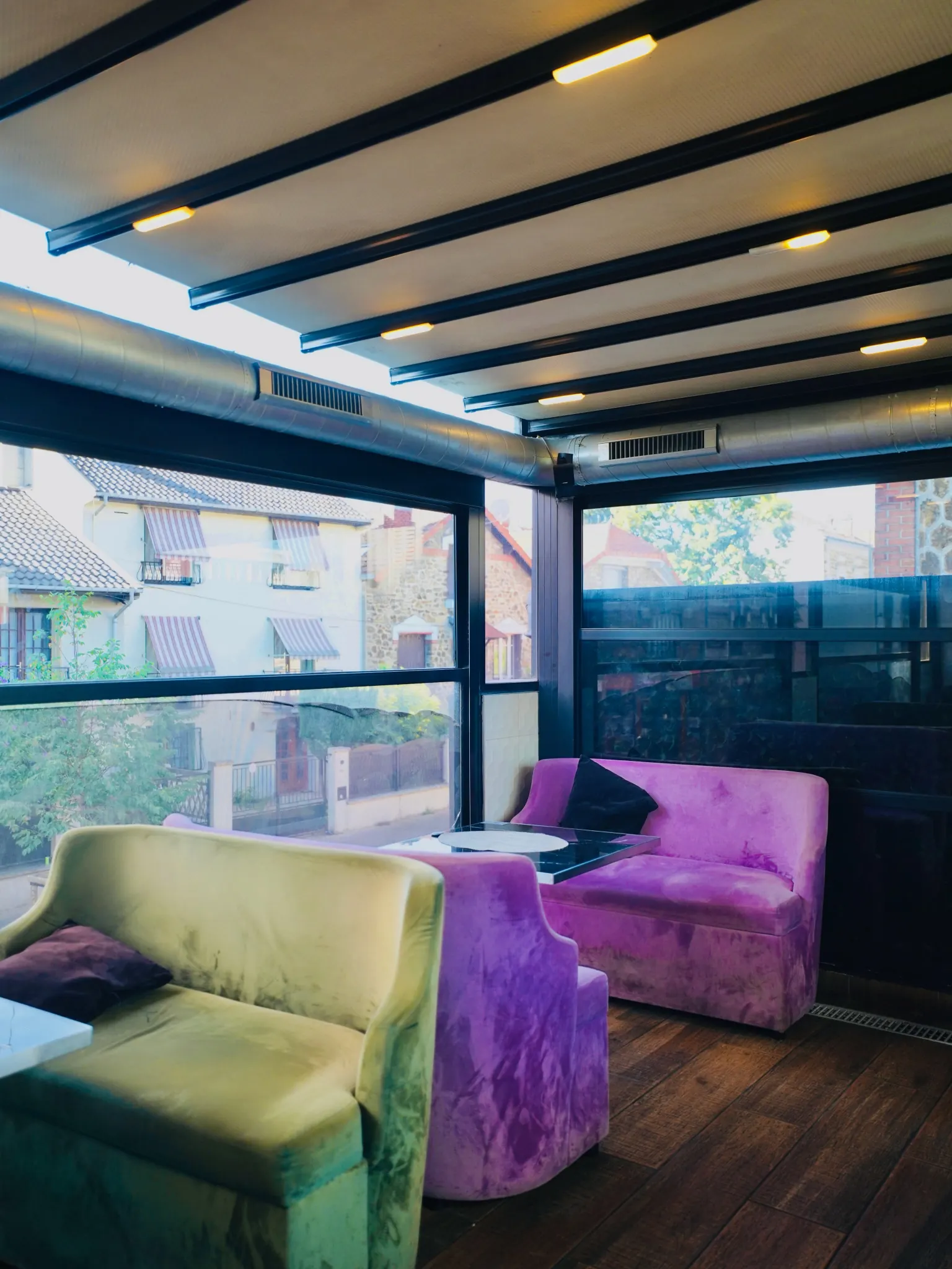 Le salon du Safe Lounge à Noisy-le-Sec, ses fauteuils verts et violets et sa grande baie vitrée